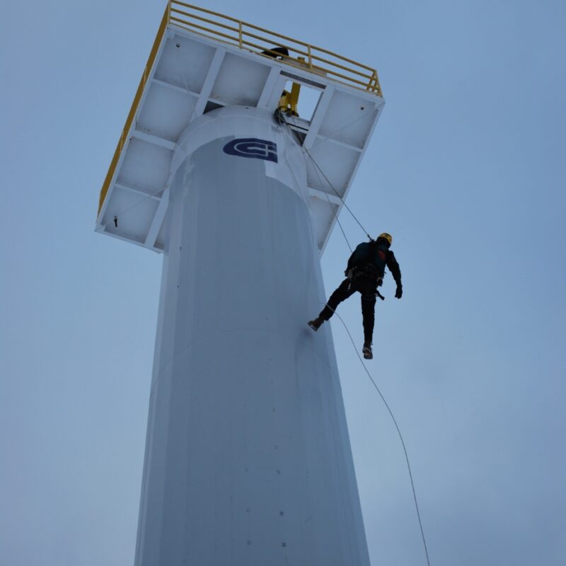 Technicien en rappel sur une structure industrielle en hauteur.